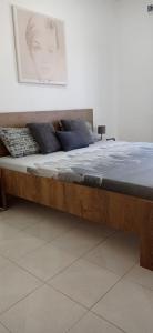 a large wooden bed with pillows on top of it at Tavira sweet home in Tavira