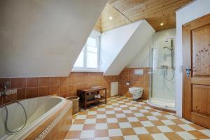 a bathroom with a tub and a toilet at Ferienhaus Schwab - Sauna, eigene Terrasse, 3 Schlafzimmer - by homekeepers in Schwarzach am Main