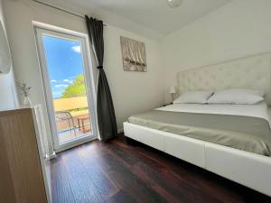 1 dormitorio con cama y ventana grande en Villa Felix, en Murter