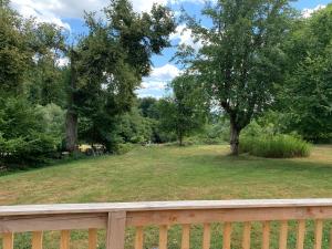 a wooden fence in front of a yard with trees at Petite maison Conjat in Saint-Julien-le-Petit