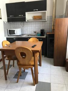 a small kitchen with a wooden table and chairs at B&B Amico in Comano Terme