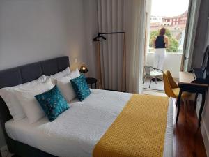 Un dormitorio con una cama y una mujer de pie en un balcón en Cool Suites, en Oporto