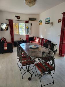 a living room with a table and a couch at Au jardin d’Aghir: Villa arborée, avec piscine privée sans vis à vis! in Aghīr