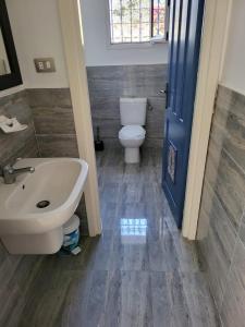 a bathroom with a white sink and a toilet at Au jardin d’Aghir: Villa arborée, avec piscine privée sans vis à vis! in Aghīr