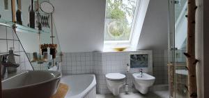 a bathroom with a sink and a toilet and a window at Ferienwohnung Wremer Straße in Wremen +64 photos