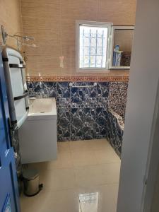 a small bathroom with a sink and a window at Au jardin d’Aghir: Villa arborée, avec piscine privée sans vis à vis! in Aghīr