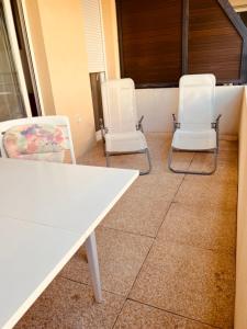twee witte stoelen en een witte tafel en stoelen bij Charming 50m With Terrace Near The Port in La Ciotat