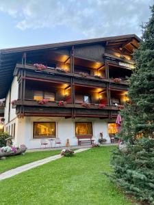 a large building with a lawn in front of it at Hotel Garni LIVING in San Candido