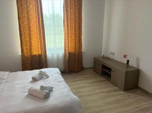 um quarto com uma cama com duas toalhas em Pensiunea Casa Petrovai em Sighetu Marmaţiei