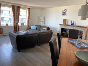 ein Wohnzimmer mit einem Sofa und einem Tisch in der Unterkunft Atlantis Appartement in Egmond aan Zee