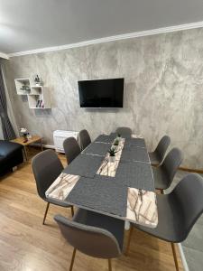 a conference room with a table and chairs and a tv at Мезонет Лапландия in Pamporovo