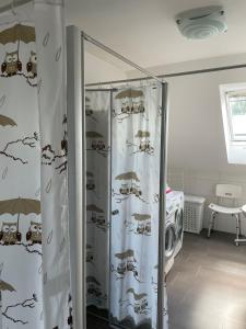 ein Bad mit einer Dusche mit Vorhängen und einer Waschmaschine in der Unterkunft Apartment 28 in Stadthagen