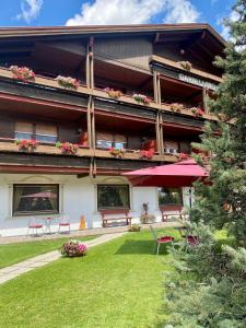 a building with benches and tables in front of it at Hotel Garni LIVING in San Candido