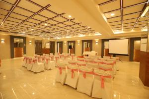 a conference room with white chairs and a screen at Hotel Keshav Residency near Medanta Pure Veg in Gurgaon