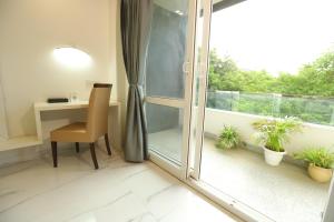 Habitación con escritorio y ventana con plantas. en Hotel Keshav Residency near Medanta Pure Veg en Gurgaon