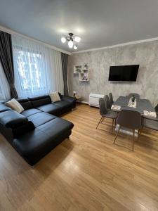 a living room with a black couch and a table at Мезонет Лапландия in Pamporovo