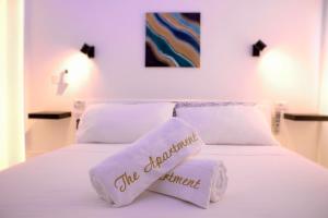 un letto bianco con due cuscini sopra di The Apartment a Porto Santo Stefano