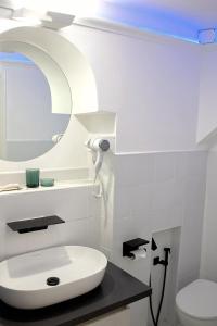 bagno bianco con lavandino e specchio di The Apartment a Porto Santo Stefano