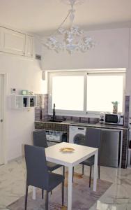 una cucina con tavolo e sedie di The Apartment a Porto Santo Stefano