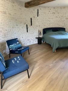 a bedroom with a bed and a chair at Ferme de Mesangeon in Beauvilliers