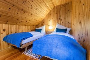 2 Betten in einem Zimmer mit Holzwänden in der Unterkunft Almhaus Falkertzeit in Koflach