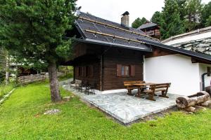 eine Holzhütte mit einem Picknicktisch im Hof in der Unterkunft Almhaus Falkertzeit in Koflach