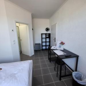 a room with a bed and a desk in a room at Zimmerwelt-Ilsfeld in Ilsfeld