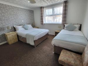 1 dormitorio con 2 camas y ventana en The Lumada, en Blackpool