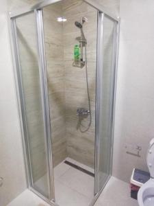 a shower with a glass door in a bathroom at Venezia Apartman in Veliko Gradište
