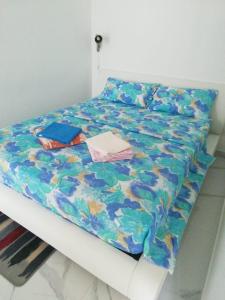 uma cama com um edredão colorido e almofadas em Venezia Apartman em Veliko Gradište