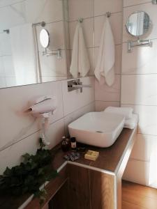 Garden Apartments في كيراموتي: حمام مع حوض أبيض ومرآة