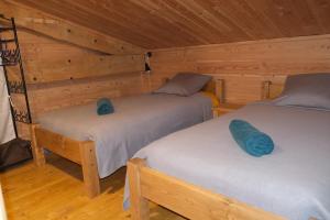 a room with two beds in a cabin at Gîte Le Corral in Cheminas