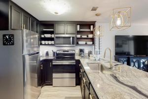 a kitchen with stainless steel appliances and black cabinets at Costa Del Sol C1- Scenic Sands in Destin