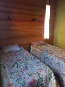 タンディルにあるcasa estilo cabañaの木製の壁の部屋にベッドが2つある +4枚の写真