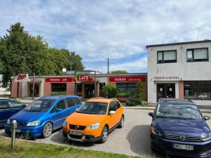 a group of cars parked in front of a store at Hotel DANIELA in Nīca