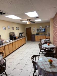 a dining room with tables and chairs and a kitchen at Econo Lodge Salina Scenic Route 89 & I-70 in Salina
