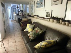 a living room with a brown leather couch and shelves at Ray's Bucktown Bed and Breakfast in Chicago