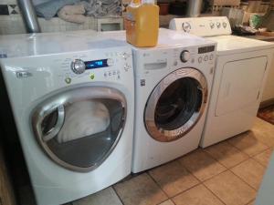 a washer and dryer with a bottle of orange juice on top at Ray's Bucktown Bed and Breakfast in Chicago
