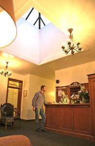 Ein Mann steht an einem Tresen in einem Hotelzimmer. in der Unterkunft Ryan Hotel in Wallace
