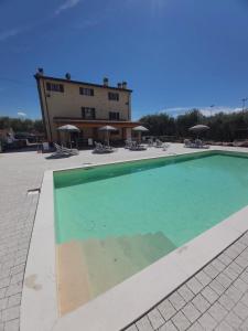 una gran piscina con sillas y un edificio en Apartments Colombara Bardolino, en Bardolino