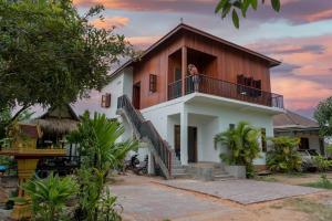 eine Frau steht auf dem Balkon eines Hauses in der Unterkunft Beyond Angkor Homestay - Private Floor 2-Bedroom & Living Room in Siem Reap