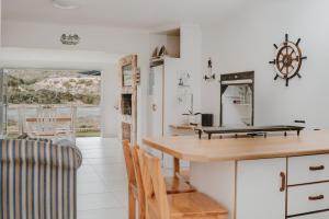 a kitchen with a counter and a table and chairs at Aloha Lodge in Stilbaai