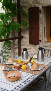 a table with two tea pots and food on it at Gîte Le Corral in Cheminas