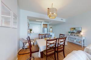 a dining room and kitchen with a table and chairs at TOPS'L Tides 704 in Destin