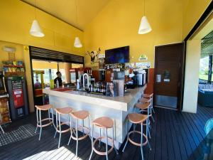 a bar in a restaurant with stools at Baia da Luz - Nuzone Apartment in Luz