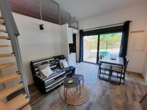 ein Wohnzimmer mit einer Treppe und einem Tisch in der Unterkunft Adorable petite maison au coeur du Luberon in Villelaure
