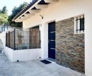 uma casa com uma porta azul e uma parede de tijolos em Adorable petite maison au coeur du Luberon em Villelaure