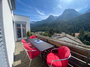 a balcony with a table and chairs and mountains at Ferienwohnung Sotcha 8c in Scuol