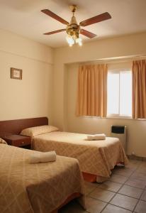 een slaapkamer met 2 bedden en een plafondventilator bij Wilson Apart Hotel in Salta