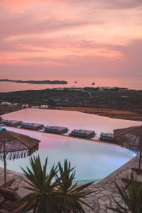 a view of a swimming pool at sunset at Mythic Paros , Adults Only in Agia Irini Paros